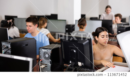 Teenager girl copying documents in computer class Teenager girl copying documents in computer class 113671452