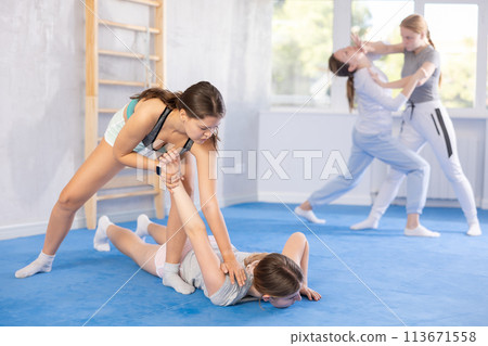Two teenage girls training in group self defense classes Two teenage girls training in group self defense classes 113671558