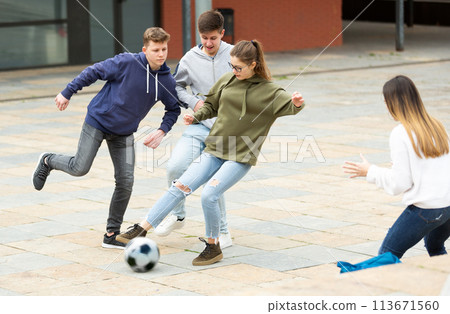 Cheerful teenagers are jogning with ball on street Cheerful teenagers are jogning with ball on street 113671560
