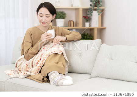 一個女人在客廳放鬆,溫暖而對寒冷敏感 一個女人在客廳放鬆,溫暖而對寒冷敏感 113671890