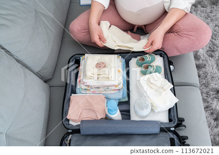 Top view of a pregnant woman packing a set of necessary things in the maternity hospital 113672021