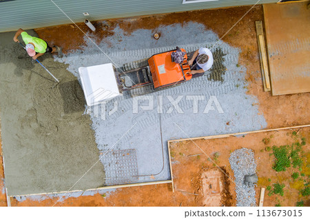 Wet cement is poured into framework during foundation construction using self dumping track concrete buggy Wet cement is poured into framework during foundation construction using self dumping track concrete buggy 113673015