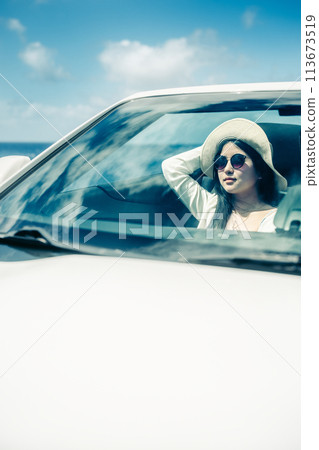 一位女士從敞篷車的車窗望向大海 113673519