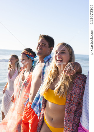 Diverse group of friends enjoy a sunny beach day 113673565