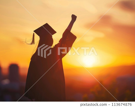 A woman in a graduation cap and gown is standing in front of a sunset A woman in a graduation cap and gown is standing in front of a sunset 113674876