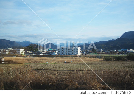 Landscapes of the countryside in Japan Showing a rice field after harvest, with a mountain view in the early winter. Landscapes of the countryside in Japan Showing a rice field after harvest, with a mountain view in the early winter. 113675630
