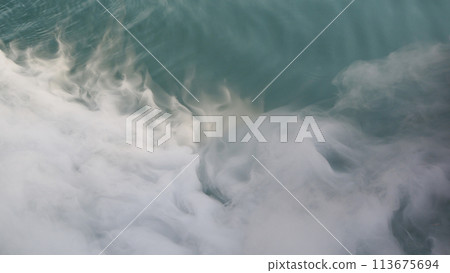 dry ice smoke floats above the water surface 113675694