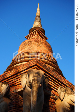 An old pagodas arounded by elephant statues the popular travel destinations in the world heritage, sukhothai hitorical park, in Thiland An old pagodas arounded by elephant statues the popular travel destinations in the world heritage, sukhothai hitorical park, in Thiland 113675720