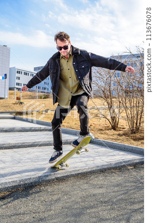 Young man riding a skateboard making tricks and jumps Young man riding a skateboard making tricks and jumps 113676078