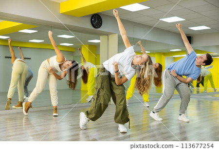 Dancer boys and girls showing different tricks and movements while dancing in studio, flexible and sportive female on floor Dancer boys and girls showing different tricks and movements while dancing in studio, flexible and sportive female on floor 113677254