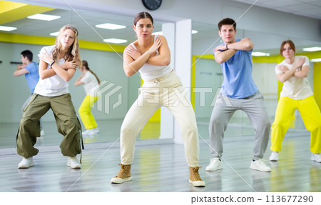 Dancer boys and girls showing different tricks and movements while dancing in studio, flexible and sportive female on floor 113677290