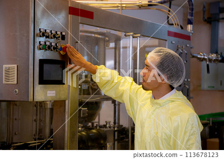Technician young man adjust control panel of machine in factory for optimal performance. 113678123