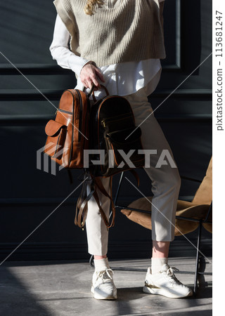 beautiful curly blond hair woman posing with a two leather backpacks beautiful curly blond hair woman posing with a two leather backpacks 113681247