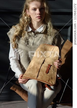beautiful curly blond hair woman posing with a beige leather backpack beautiful curly blond hair woman posing with a beige leather backpack 113681272
