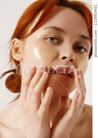 Smiling woman take-off under eye collagen patches 113683481