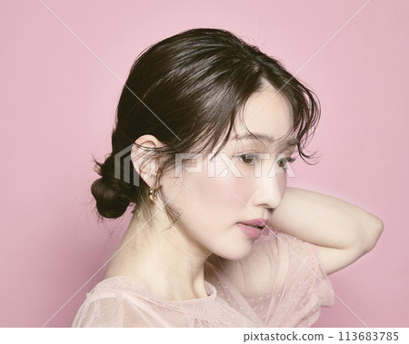 Portrait of a young glamorous woman against a pink background Portrait of a young glamorous woman against a pink background 113683785