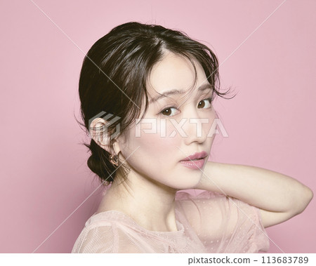粉紅色背景下拍攝的一位年輕迷人女性的肖像 粉紅色背景下拍攝的一位年輕迷人女性的肖像 113683789