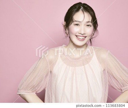 Portrait of a young glamorous woman against a pink background Portrait of a young glamorous woman against a pink background 113683804