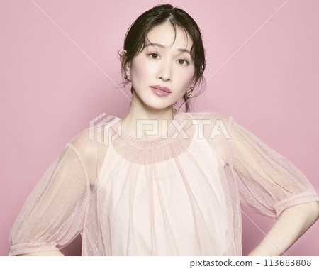Portrait of a young glamorous woman against a pink background Portrait of a young glamorous woman against a pink background 113683808