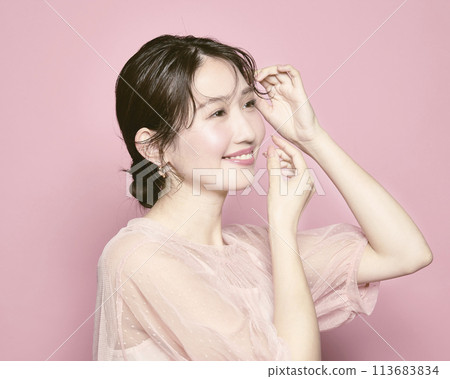 Portrait of a young glamorous woman against a pink background 113683834