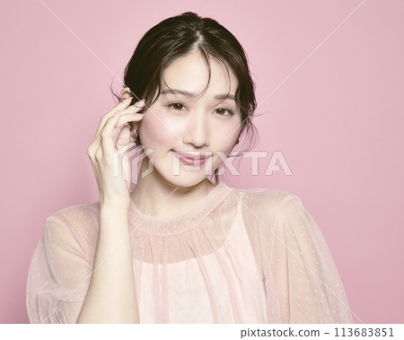 Portrait of a young glamorous woman against a pink background Portrait of a young glamorous woman against a pink background 113683851
