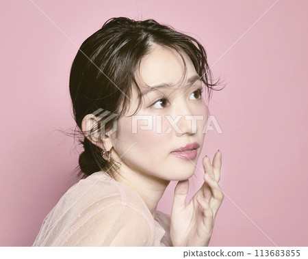 Portrait of a young glamorous woman against a pink background Portrait of a young glamorous woman against a pink background 113683855