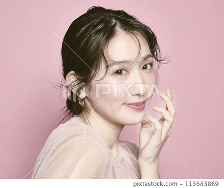 Portrait of a young glamorous woman against a pink background Portrait of a young glamorous woman against a pink background 113683869