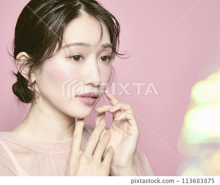 Portrait of a young glamorous woman against a pink background Portrait of a young glamorous woman against a pink background 113683875