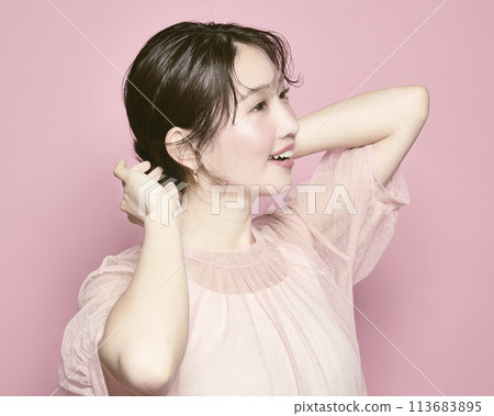 Portrait of a young glamorous woman against a pink background Portrait of a young glamorous woman against a pink background 113683895
