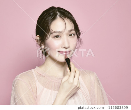 Portrait of a young glamorous woman against a pink background Portrait of a young glamorous woman against a pink background 113683899