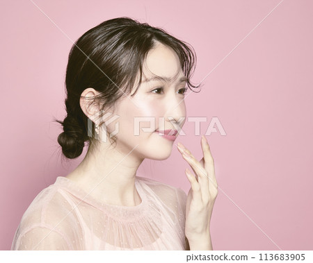 粉紅色背景下拍攝的一位年輕迷人女性的肖像 113683905