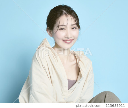 藍色背景下一位年輕女子的肖像 113683911