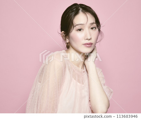 Portrait of a young glamorous woman against a pink background Portrait of a young glamorous woman against a pink background 113683946