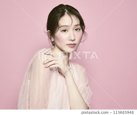 Portrait of a young glamorous woman against a pink background Portrait of a young glamorous woman against a pink background 113683948