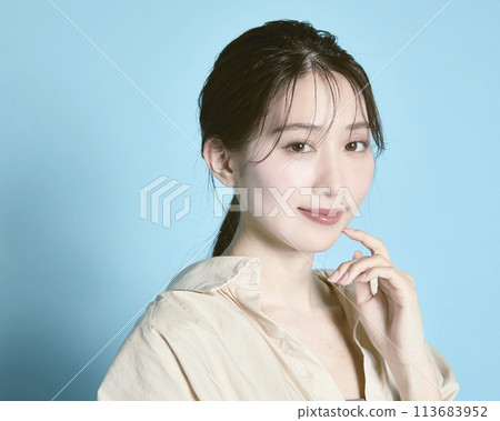 Portrait of a young woman against a blue background 113683952