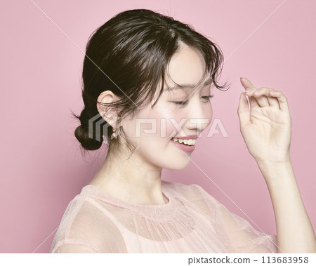 Portrait of a young glamorous woman against a pink background Portrait of a young glamorous woman against a pink background 113683958