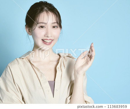 Portrait of a young woman against a blue background Portrait of a young woman against a blue background 113683959