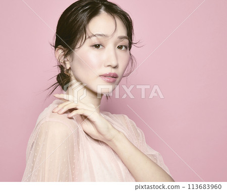 Portrait of a young glamorous woman against a pink background Portrait of a young glamorous woman against a pink background 113683960