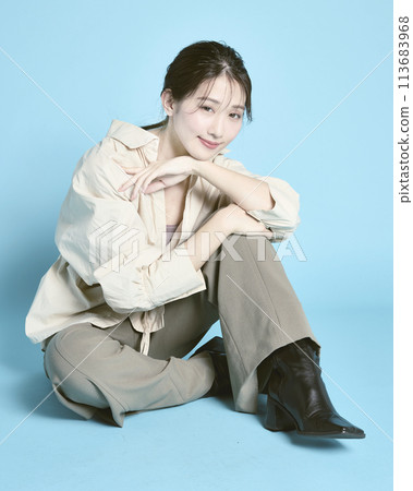 Portrait of a young woman against a blue background Portrait of a young woman against a blue background 113683968