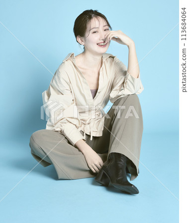 Portrait of a young woman against a blue background 113684064