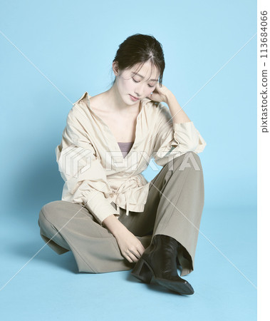 Portrait of a young woman against a blue background 113684066