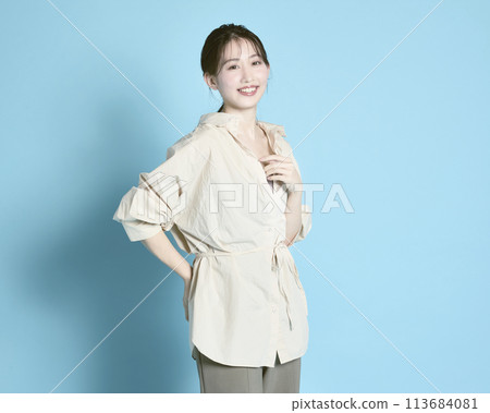 Portrait of a young woman against a blue background 113684081