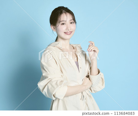 藍色背景下一位年輕女子的肖像 113684083