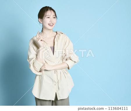 Portrait of a young woman against a blue background 113684111