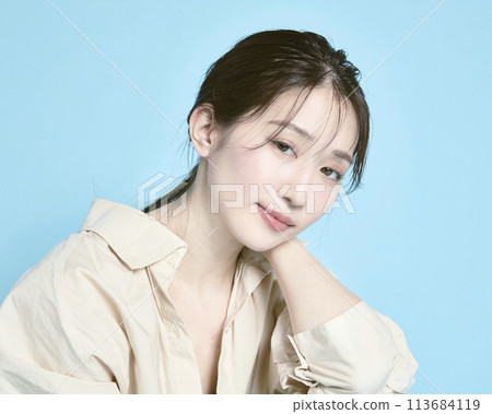 藍色背景下一位年輕女子的肖像 113684119