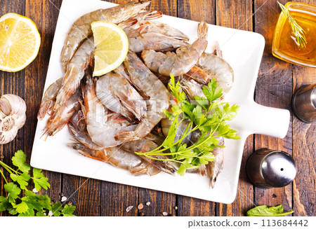 Uncooked Raw peeled tiger white shrimp prawn. wooden background. 113684442