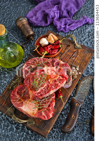 Top view of raw meat pieces placed on wooden tray sprinkled with salt Top view of raw meat pieces placed on wooden tray sprinkled with salt 113684453