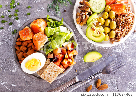 salad with salmon, boiled egg, bean, tomato, salad and almond nuts. 113684465