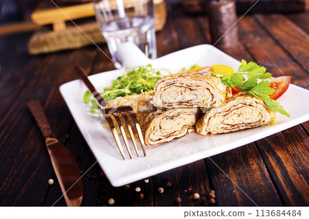 Dashimaki tamago, Japanese style rolled omelette in dish on wooden table Dashimaki tamago, Japanese style rolled omelette in dish on wooden table 113684484