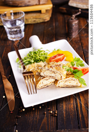 Dashimaki tamago, Japanese style rolled omelette in dish on wooden table Dashimaki tamago, Japanese style rolled omelette in dish on wooden table 113684486